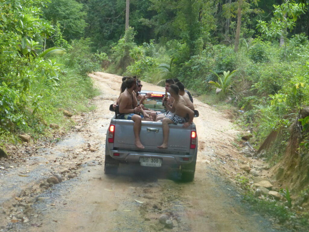Vacationers on Koh Phangan island in the back of a pick up truck 